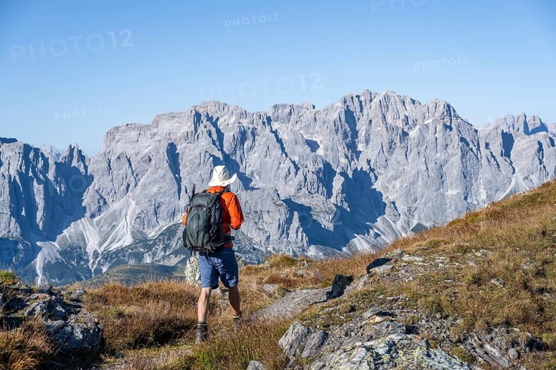 Mountaineer on hiking trail in front of rocky mountain peaks, behind Sesto Dolomites, Carnic Main Ridge, Carnic High Trail, Carnic Alps, Carinthia, Austria, Europe