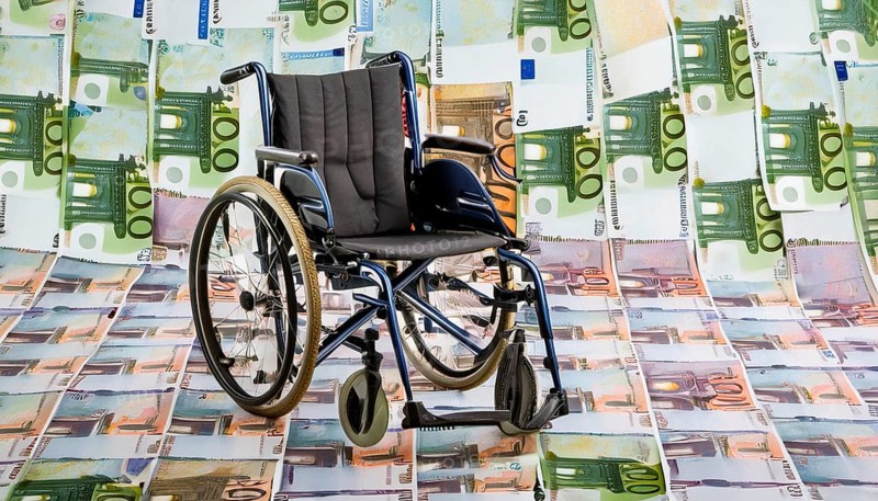 Symbol long-term care insurance, care costs, disability, a wheelchair stands on a surface of euro notes, money, AI generatedSymbol photo, AI generated, AI generated