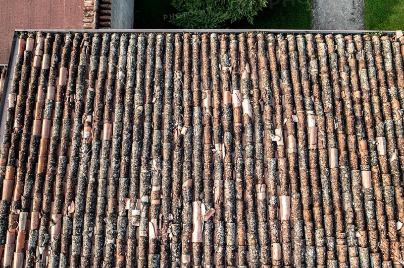Bird's-eye view of worn terracotta tiles covering residential rooftops