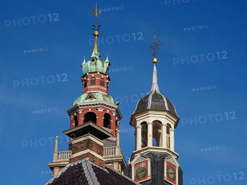 Two historic church towers with weather vane and clock under a blue sky, two towers of historic houses with a clock, Leer, Germany, Europe