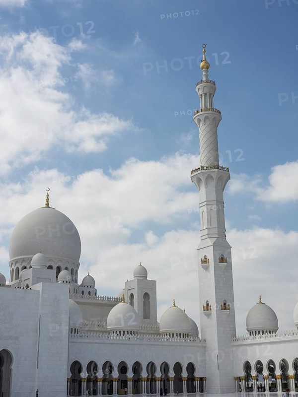 Magnificent mosque with several domes and a high minaret under a cloudy sky, large mosque with white domes and large minarets, abu dhabi, arab emirates