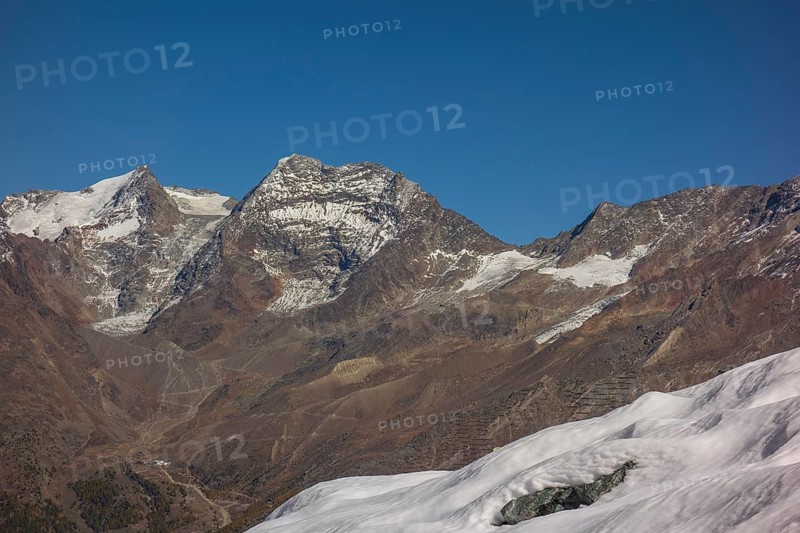 Snow covered mountains and rocky peaks under a clear blue sky, snow on high mountains in the alps, blue sky over mountains, Saas fee, Switzerland, Europe