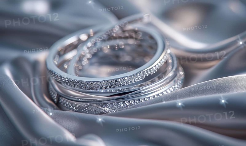 Set of silver bracelets arranged on a satin material background AI generated