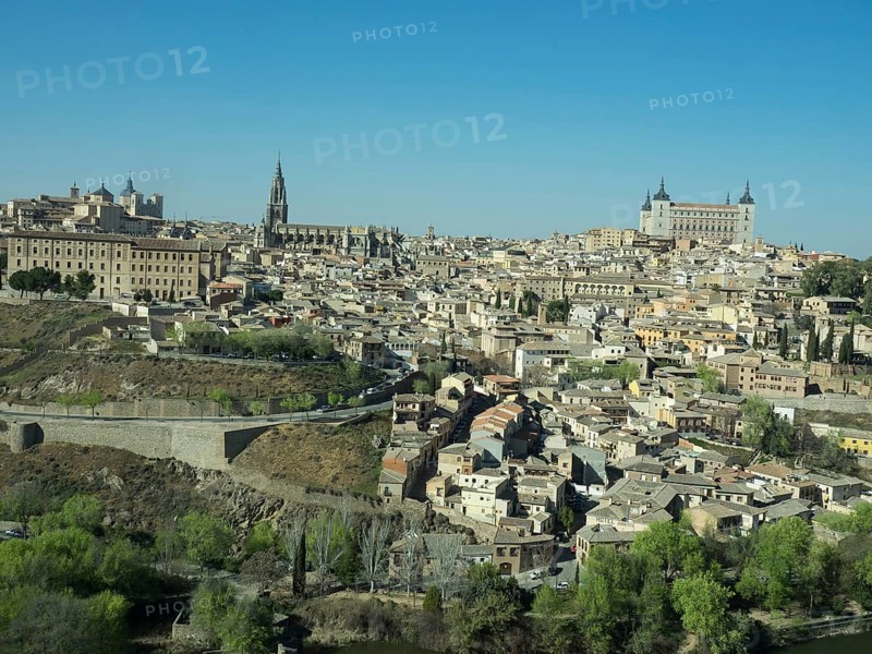 Historic old town with a river landscape and striking church towers, framed by hills, under a clear blue sky, historic town with old houses and large churches on a small river in front of a blue sky, toledo, spain