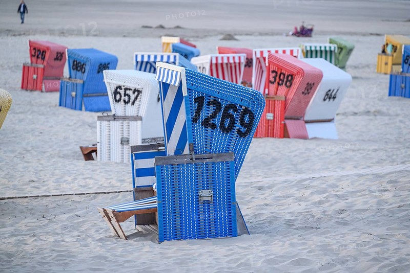 Blue beach with colourful beach chairs, relaxed atmosphere in typical beach holiday ambience, many colourful beach chairs on a warm summer evening by the sea, langeoog, germany