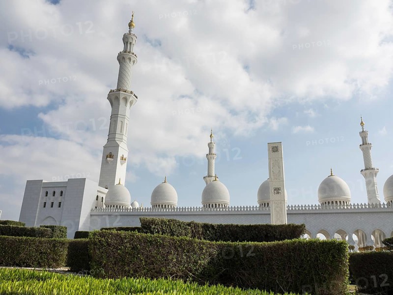 Imposing mosque with domes, minaret and manicured gardens against a cloudy sky, beautiful mosque with white domes and beautiful minarets, abu dhabi, arab emirates