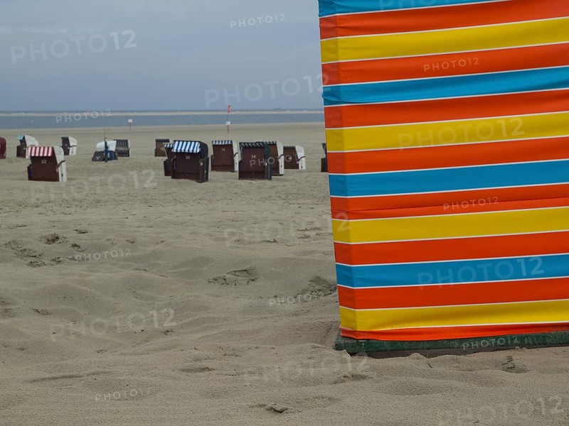 A colourful strip of sand on the beach with beach chairs in the background, extensive sand, beach chairs and beach tents by the sea under a cloudy sky, boardwalk in the sand, Borkum, Germany, Europe