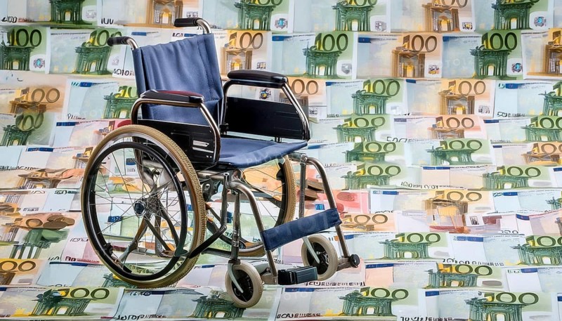 Symbolic long-term care insurance, care costs, disability, a wheelchair stands on a surface of euro notes, money, AI generated, AI generated