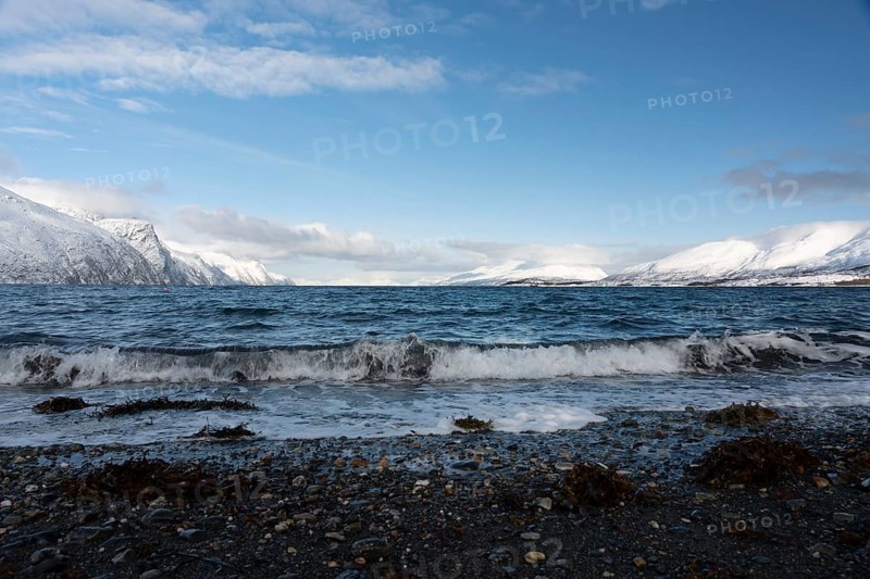 View into the sea with mountains of the Lyngenfjord in winter, Norway, Europe