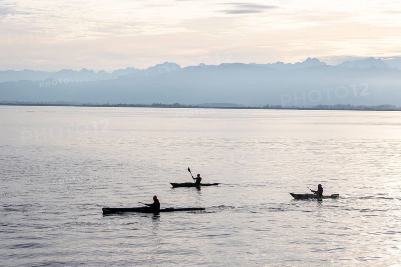 Kayakers paddling in Lake Constance in the evening light, snow-covered mountain peaks, Lindau Island, Lake Constance, Bavaria, Germany, Europe