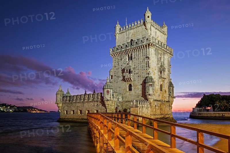 Belem Tower or Tower of St Vincent famous tourist landmark of Lisboa and tourism attraction on bank of Tagus River (Tejo) after sunset in dusk twilight with dramatic sky. Lisbon, Portugal, Europe