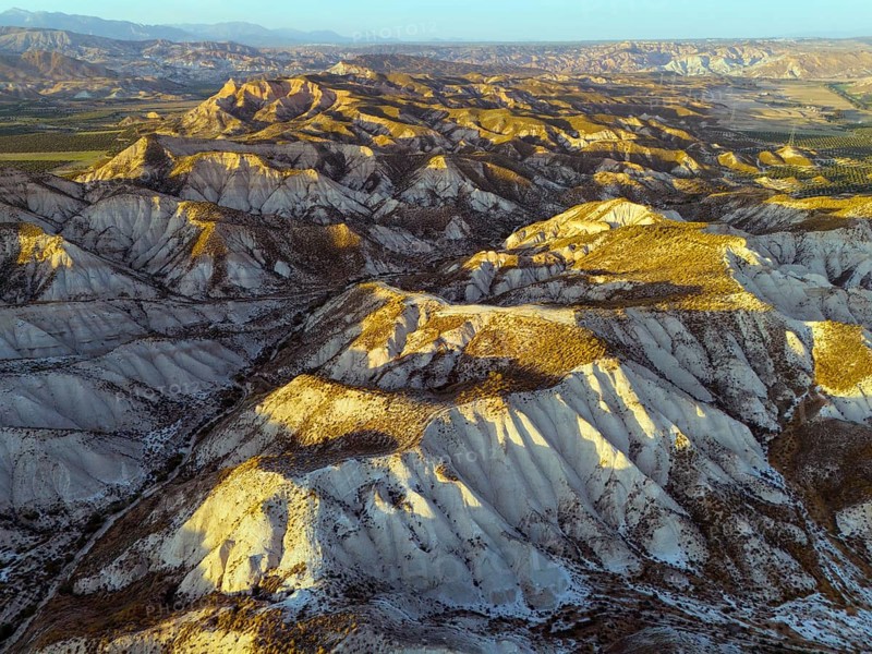 Hilly desert landscape in warm light with deep shadows and clear view of the geographical features, aerial view, Dehesas de Guadix, Gorafe Desert, Granada, Andalusia, Spain, Europe