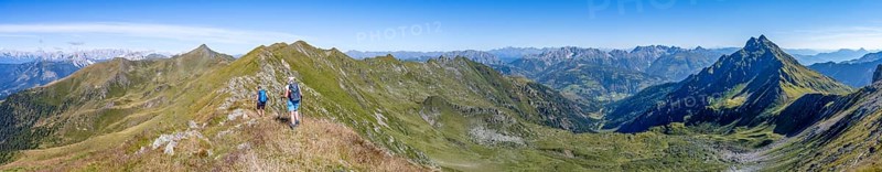 Panorama, mountaineer on a grassy ridge, view of the Lesach Valley and mountain panorama, Carnic High Trail, Carnic Main Ridge, Carnic Alps, Carinthia, Austria, Europe