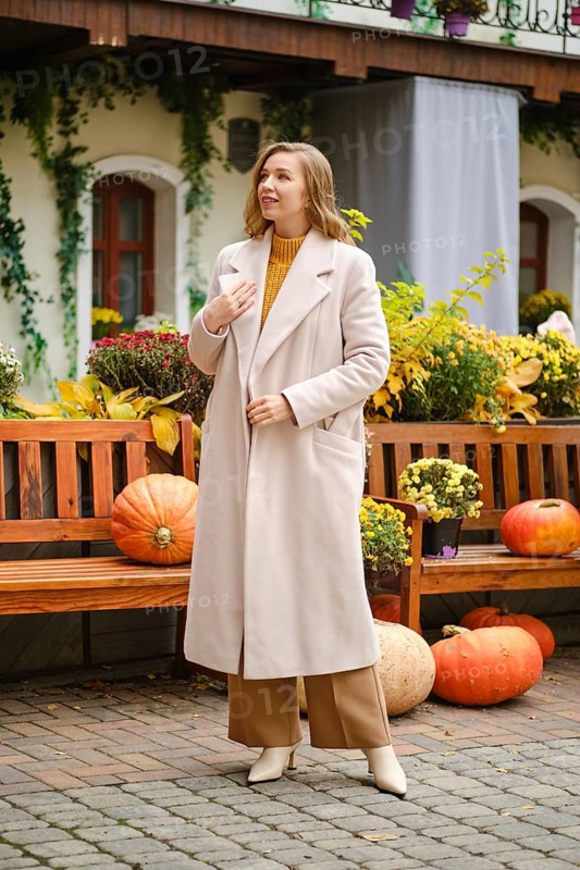Young woman with unfastened coat at pumpkin festival