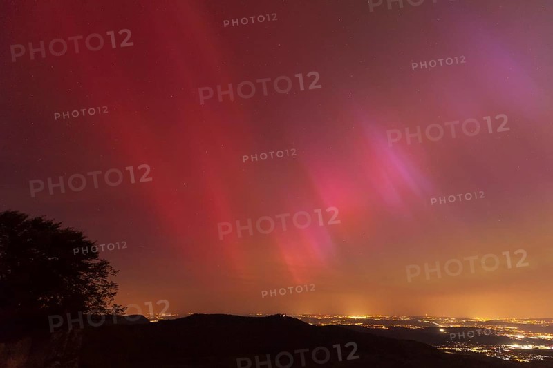 Northern lights in Germany. Very strong auroras over the Stuttgart metropolitan region. View from Breitenfels near Ochsenwang on the Swabian Alb, 10.05.2024. View towards Stuttgart, Teck Castle in the foreground