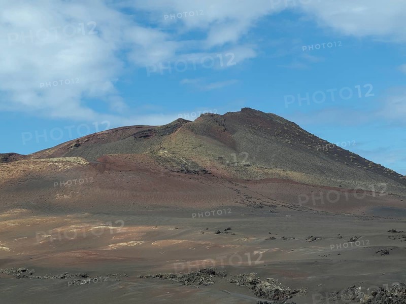 Fascinating volcanic landscape with barren soil and blue sky, barren landscape of lava mountains, lanzarote, spain