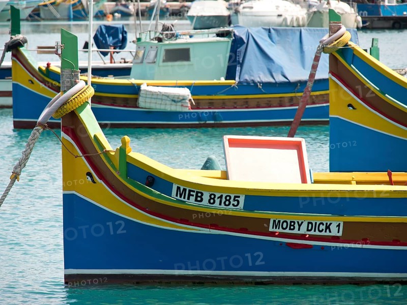 Several colourful fishing boats lying quietly in the harbour, many colourful fishing boats in a harbour in the Mediterranean, Marsaxlokk, malta