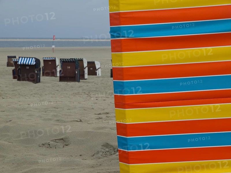 An empty beach with colourful stripes in the foreground and beach chairs in the background, beach chairs and beach tents by the sea under a cloudy sky, boardwalk in the sand, Borkum, Germany, Europe