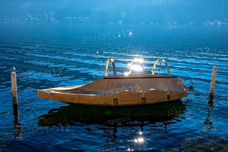 Beautiful Old Fishing Boat on Lake Lugano with Sun Reflection in a Sunny Day in Morcote, Ticino, Switzerland, Europe