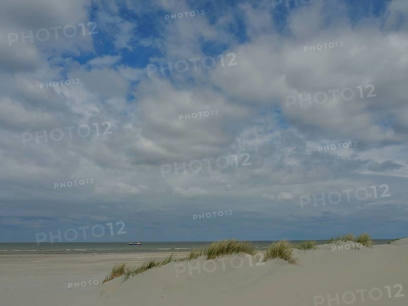 Spacious beach with sand dunes, calm sea and partly cloudy sky, dunes by the sea with clouds in the blue sky, nes, ameland, the netherlands