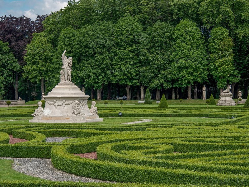 Spacious baroque garden with symmetrical hedges and several sculptures, surrounded by trees, park with green hedges, small paths and old statues, nordkirchen, germany