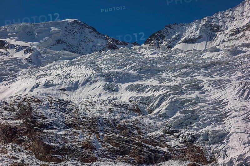 Glacier and snow covered mountain with bright blue sky, snow on high mountains in the alps, blue sky over mountains, Saas fee, Switzerland, Europe