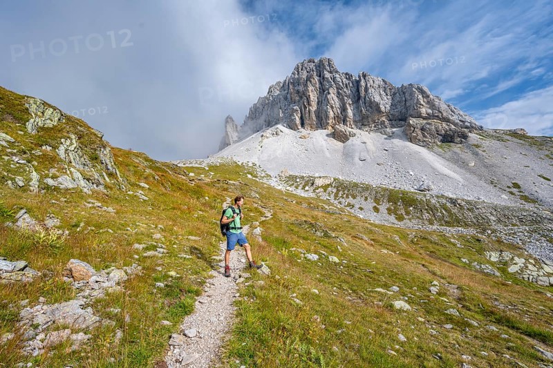 Mountaineer on a hiking trail, rocky summit of the Grosser Kinigat in the background, Carnic High Trail, Carnic Alps, Carinthia, Austria, Europe