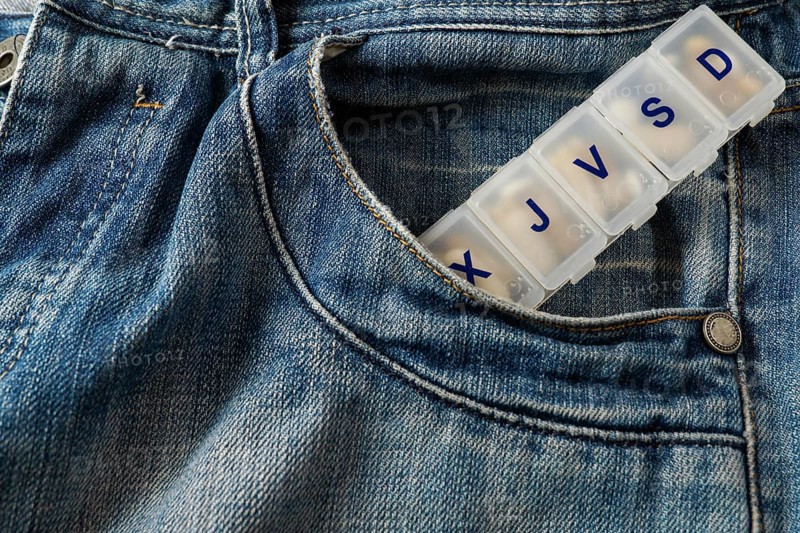 Jeans with a pillbox coming out of the pocket