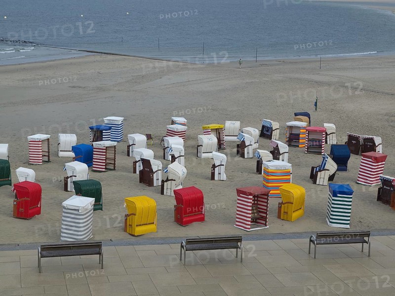 Many colourful beach chairs on the beach, the sea in the background and a cloudy sky, beach chairs and beach tents by the sea under a cloudy sky, boardwalk in the sand, Borkum, germany