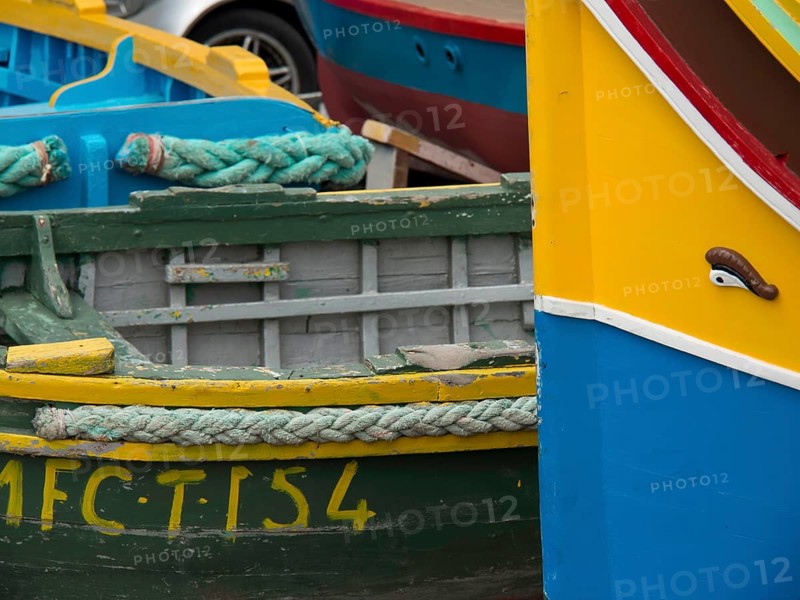 Close-up of colourful fishing boats lying next to each other in the harbour, many colourful fishing boats in a harbour in the Mediterranean Sea, Marsaxlokk, malta