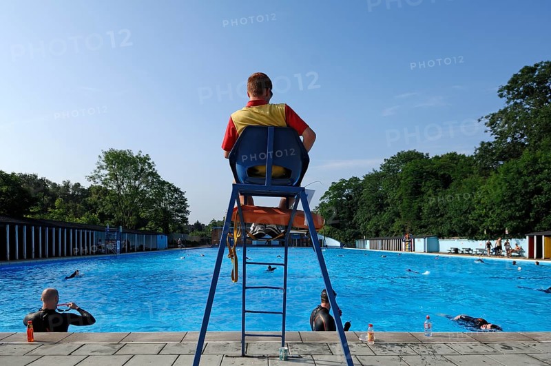 Lifeguard on duty in the high seat at the large outdoor swimming pool Tooting Bec Lido (91m x 30m), Tooting Bec Common, Tooting Bec, London, England, United Kingdom, Europe