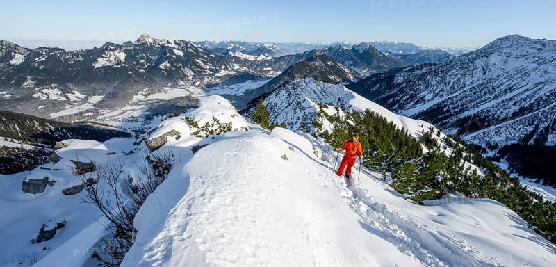 Mountaineer on the summit of the Aiplspitz in the snow, snow-covered mountain landscape with mountain pines in winter, ski tour to the Aiplspitz, Mangfall mountains, Bavarian Prealps, Bavaria, Tyrol