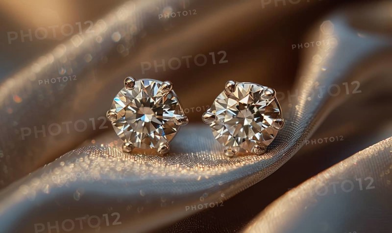 A pair of sparkling diamond earrings arranged on a sleek satin material background AI generated