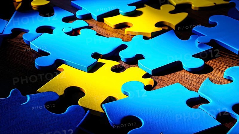 Illustration of scattered blue and yellow puzzle pieces sprawled across as a wallpaper background, AI generated