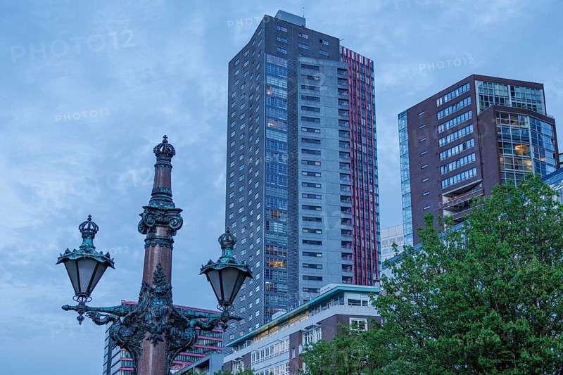 City view with modern skyscrapers and an old lamp post in the foreground under a blue sky, small harbour in a big city with a lighthouse and modern houses, Rotterdam, Netherlands