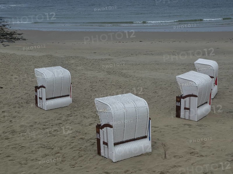 Four white beach chairs on an empty beach with calm sea in the background, beach chairs and beach tents by the sea under a cloudy sky, boardwalk in the sand, Borkum, Germany, Europe