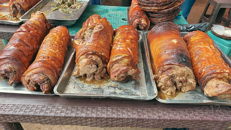 Rows of golden brown roasted pork belly or lechon liempo displayed at a street market showing an authentic filipino local delicacy and food heritage of the Philippines