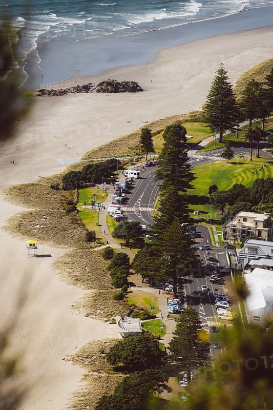 View from the viewpoint of Mount Manganui with a view of a road on the beach with the sea in the background. Taken in Tauranga, New Zealand, Oceania