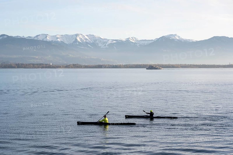 Kayakers paddling in Lake Constance in the evening light, snow-covered mountain peaks, Lindau Island, Lake Constance, Bavaria, Germany, Europe