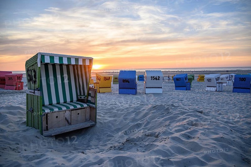 Colourful beach chairs on the beach at sunset, an open basket in the foreground, many colourful beach chairs on a warm summer evening by the sea, langeoog, germany