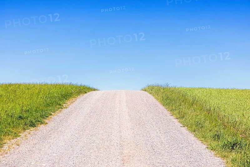 Gravel road on a hill a sunny summer day with a clear blue sky