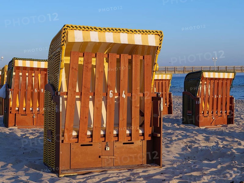 Close-up of a beach chair on the beach with other baskets and a pier in the background, beach chairs in the morning light with blue sky by the sea, pier in the sea, Binz, Germany, Europe
