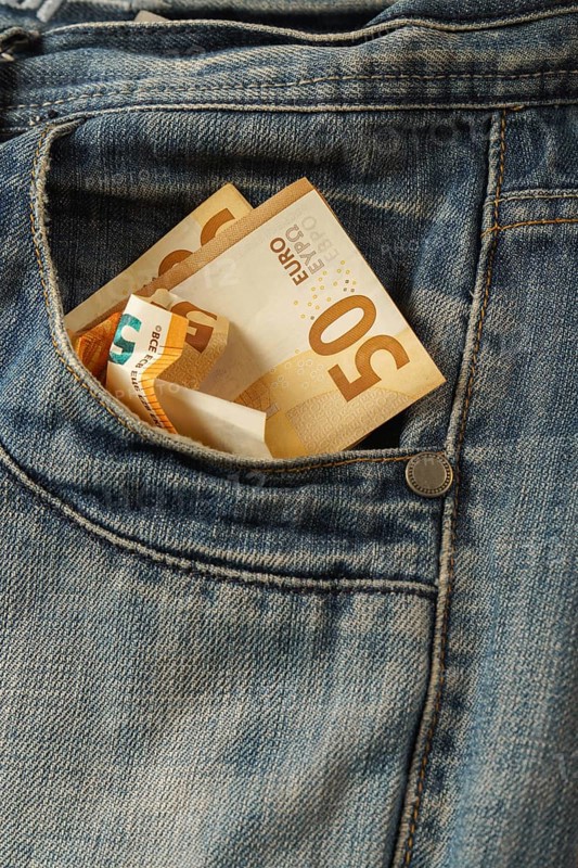 Euro bills coming out of a jeans pocket