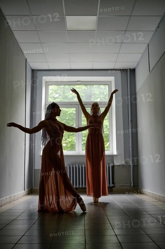 Silhouette of two female dancers rehearsing choreography in the hallway of theatre
