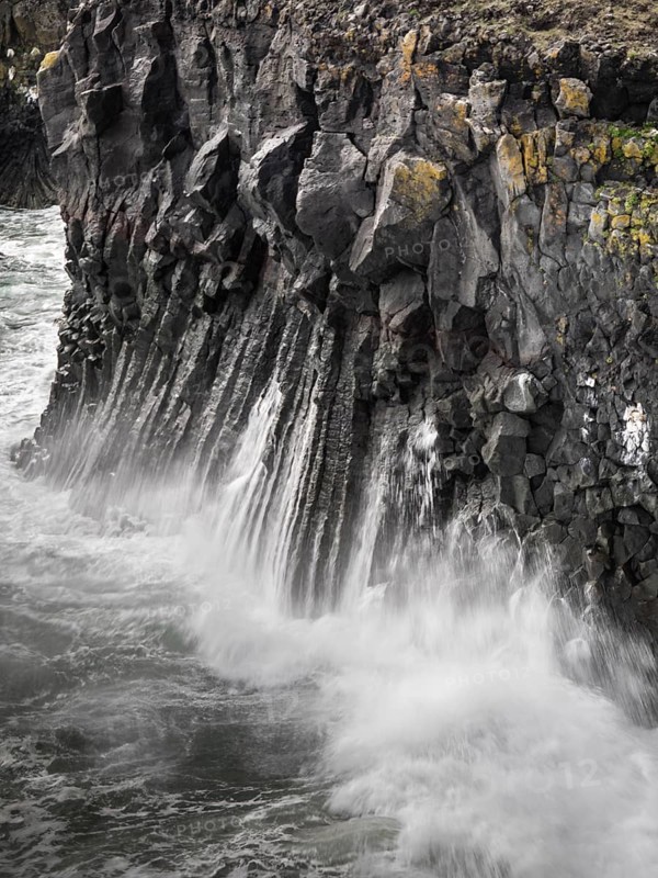 Surf on dramatic basalt cliffs, surrounded by sea spray and powerful natural scenery, Iceland, Europe