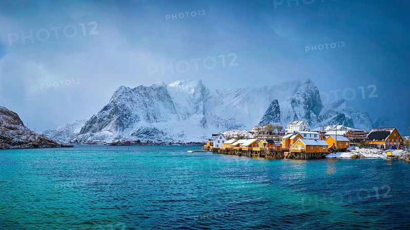 Panorama of yellow rorbu houses of Sakrisoy fishing village with snow in winter. Lofoten islands, Norway, Europe