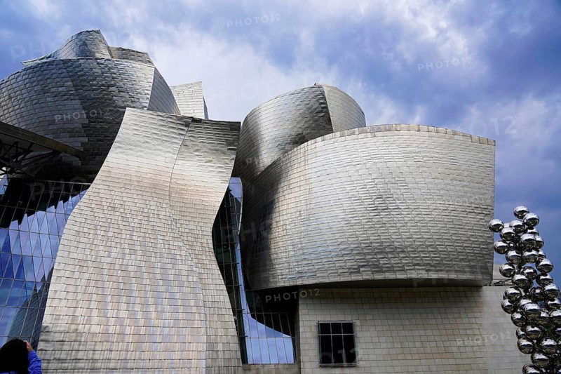 Guggenheim Museum Bilbao on the banks of the Nervion River, architect Frank O. Gehry, Bilbao, Complex architectural structure with sculptural metallic forms against a cloudy sky, Guggenheim Museum, architect Frank O. Gehry, Bilbao, Bizkaia Province, Basque Country, Spain, Europe