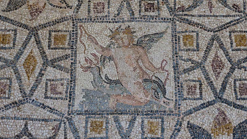 Eros riding a dolphinAncient mosaic depicting a winged man, with geometric patterns and mythological themes, outdoor area, Archaeological Museum, Old Town, Rhodes Town, Rhodes, Dodecanese, Greek Islands, Greece, Europe