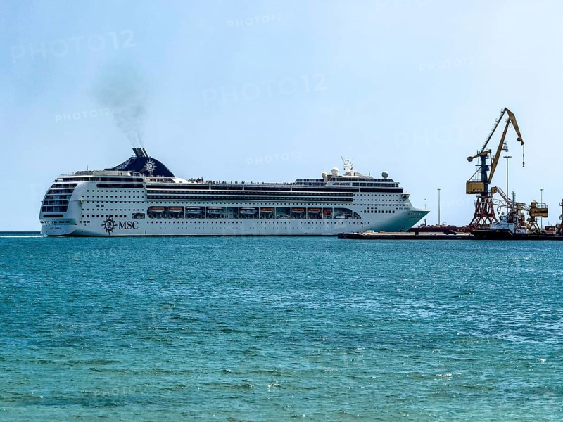 Huge cruise ship from shipping company MSC arrives in Iraklion harbour emitting plume of exhaust fumes from diesel, Heraklion, Crete, Greece, Europe