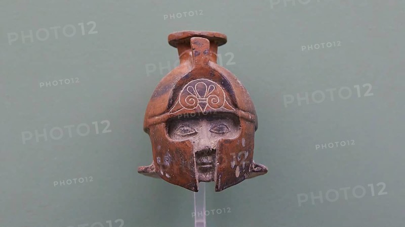 Aryballos, Ceramic vessel, Ancient sculpture of a helmet with a human face in front, brown against green background, Interiors, Archaeological Museum, Old Town, Rhodes Town, Rhodes, Dodecanese, Greek Islands, Greece, Europe